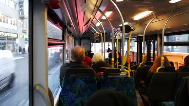 Mensen in een openbare bus rijden op straat van een Europese stad — Stockvideo
