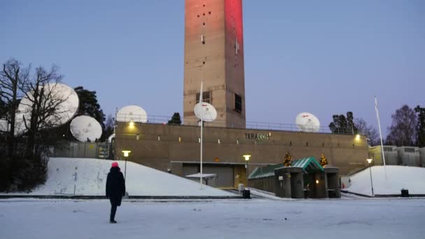 Mujer caminando cerca de la Torre de TV Kaknas en Estocolmo, Suecia. Panorámica a la parte superior — Vídeos de Stock