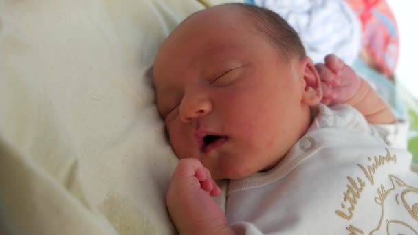 Lovely infant sleeping in a crib, moving the head and trying to open his eyes — Stock Video