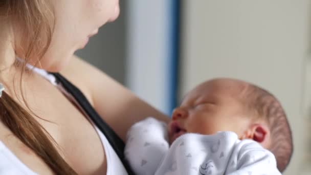 Nahaufnahme einer Frau, die ihr Baby hält und mit ihm spricht. Handschuss — Stockvideo