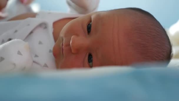 Bebé tranquilo con ropa blanca acostado mientras el padre cambia el pañal — Vídeos de Stock