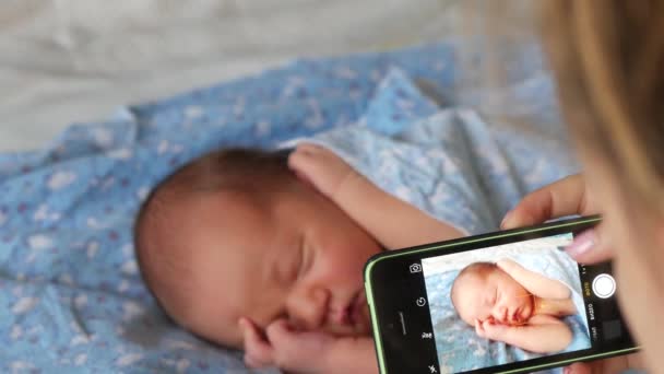 Mladá žena vyfotit její sladké spaní novorozence s chytrým telefonem — Stock video