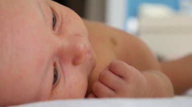 Onun arkasında yatan ve onun bacakları ve kolları hareket şirin bebek çocuk. Atış kapatın