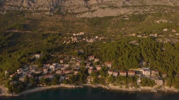 Volando lejos de la cresta rocosa y la ciudad turística en una orilla del mar. Aérea de Croacia — Vídeos de Stock