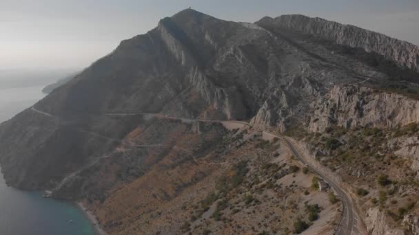Road on a slope of rocky mountain. Coastal rocks over Adriatic Sea. Aerial of Croatia — Stock Video