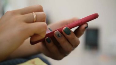 Kadın akıllı telefondan dokunmatik ekranı kaydırıyor. Manikürlü kadın ellerini kapat.