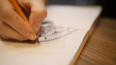 Çizim defterine mandala çizmek için kadın eli işaretliyor. Yakın çekim.