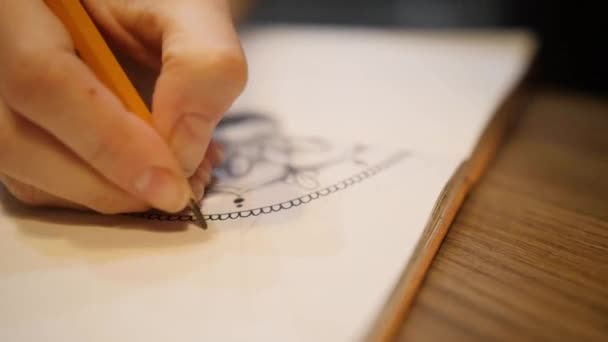 Női kéz jelölés egy papíron rajzolás mandala vázlatfüzetben. Közelkép.