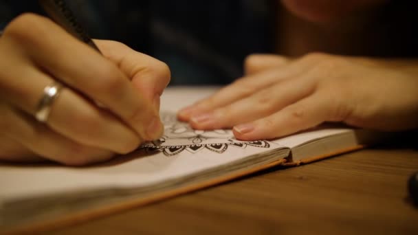 Menina desenha mandala detalhada com caneta em scketchbook. Padrão simétrico no papel — Vídeo de Stock