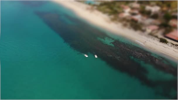 Kippbewegungen der Boote treiben auf klarem türkisfarbenem Wasser am Sandstrand des italienischen Badeortes. Luftaufnahme — Stockvideo