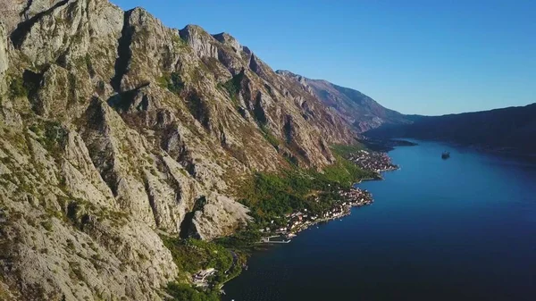 Rocky tepesi, deniz limanı ve kıyı köyleri. Güneşli Kotor Körfezi 'nde hava manzarası