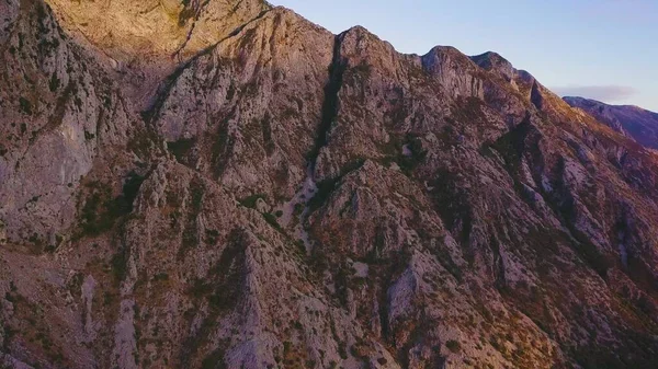 Gün batımında bir dağın kayalık yamaçlarında güneş ışığı ve gölgeler. Döndürme çekimi