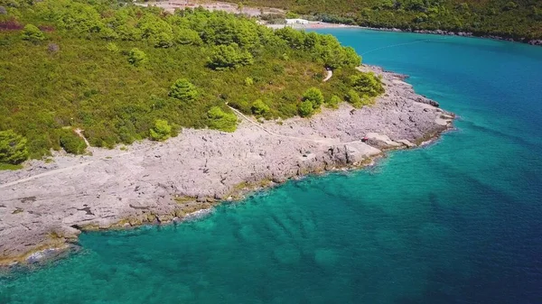 Kayaların arasında küçük bir sahil ve Adriyatik Denizi 'nin berrak turkuaz suları. Karadağ 'ın havadan görünüşü