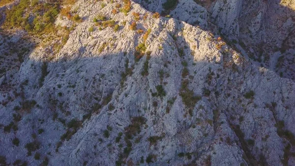 Kayalık zirvenin üzerinde uçuyor. Stony Dağı 'nda gölgeler ve gün batımı. Hava görüntüsü