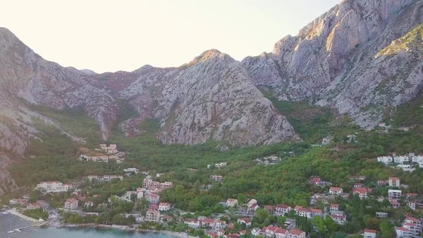 Dağın eteğindeki ormanda bir köy. Karadağ 'daki Kotor Körfezi kıyısında hava manzarası