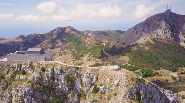 Güneşli bir günde Karadağ 'ın Lovchen Dağı' nın tepesindeki anıt mezarın hava görüntüsü