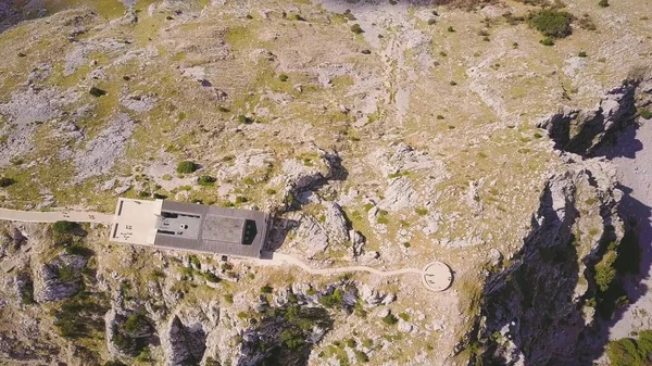 Güneşli bir günde Karadağ 'ın Lovchen Dağı' nın tepesindeki anıt mezarın hava görüntüsü