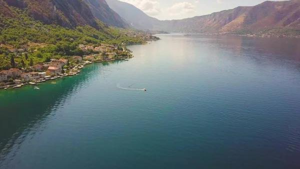 Deniz koyunun kıyısındaki kıyı kasabalarının hava manzarası. Sisli dağlar suyu yansıtır