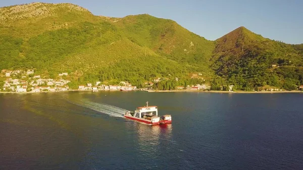 Feribot Karadağ 'ın Kotor Körfezi kıyısındaki bir sahil kasabasından ayrılıyor. Hava görünümü