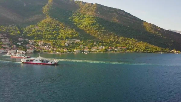 Feribotlar Kotor Körfezi kıyısındaki kıyı kasabaları arasında yüzerler. Hava görüntüsü