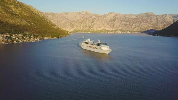 Gemi gemisi güneşli dağların arasındaki körfezde yüzüyor. Karadağ 'ın Kotor Körfezi havadan görünüşü