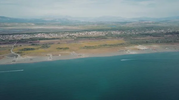 Sürat tekneleri uzun kumlu sahil boyunca ilerler. Karadağ 'ın Velika Plaza kentinin hava manzarası