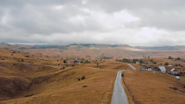 Hava: küçük dağlık köye doğru yol üzerinde uçuyor. Bulutlar dağların tepelerini kaplıyor