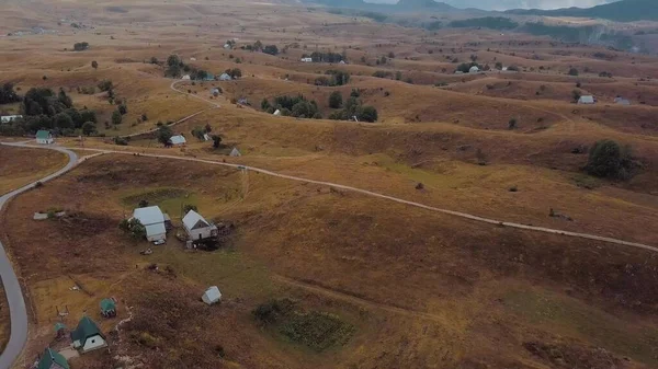 Küçük dağlık bir köy ve dar bir yol. Bulutlar dağların tepelerini kaplar