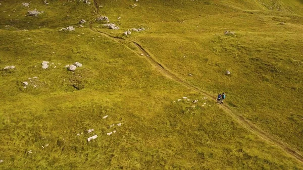 İki yürüyüşçü dağ yolunda yürüyor. Güneşli bir günde Dinarik Alpleri 'nin hava görüntüsü.