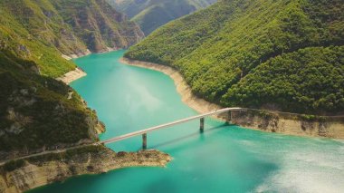 Piva Gölü üzerindeki derin kanyon köprüsü. Parlak güneşli Karadağ dağlarının havası