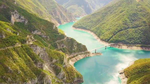 Piva Kanyonu 'nun ve nehrin üzerindeki köprünün havadan görüntüsü. Su ve kayalar üzerindeki gölgeler