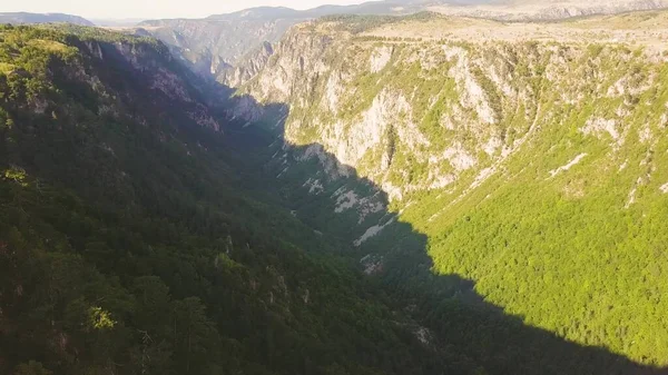 Dinaric Alpleri 'ndeki ağaçlık kanyonda güneş ışığı ve gölge. Havadan dağ manzarası, dönüm noktası