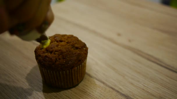 Mani spremendo panna montata sacchetto di pasticceria per decorare il topping torta — Video Stock