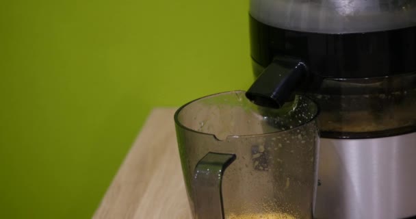 The juice from the juicer is poured into a cup. Close-up. — Stock Video