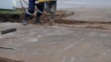 İşçi sokakta inşaat jackhammer kullanarak. Otomatik matkap ram kum yolda olan adam. Yol çalışması. İnşaat, titreşim, yakın çekim