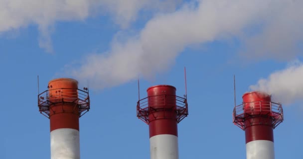 Tres tubos industriales de la planta con humo en invierno — Vídeos de Stock