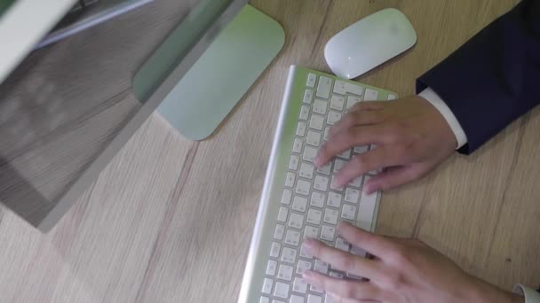 Вдумчивый молодой бизнесмен, работающий на компьютере и планшете ПК, логотип удален — стоковое видео