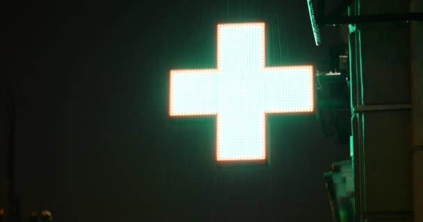 Farmacie iluminată sau semn de spital pe timp de noapte cu ploaie — Videoclip de stoc