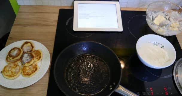 Woman looks at the Ipad and the recipe to cook curd dessert — Stock Video