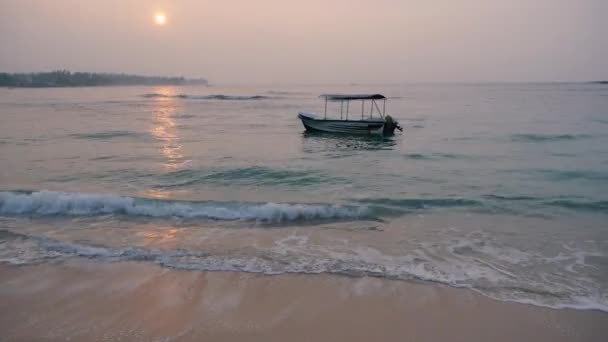 Mar tranquilo con un barco de balanceo solo al amanecer, Sri lanka, playa Unawatuna — Vídeo de stock