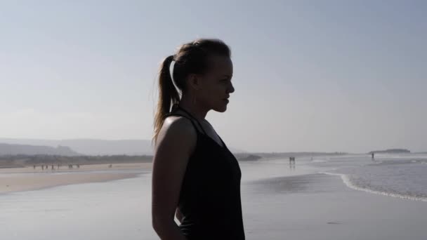 Portrait of young woman as silhouette by the sea — Stock Video