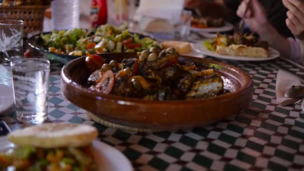 Tagine marroquí con carne de res, garbanzos, calabaza y tomates cherry en una mesa de madera. Enfoque selectivo — Vídeos de Stock