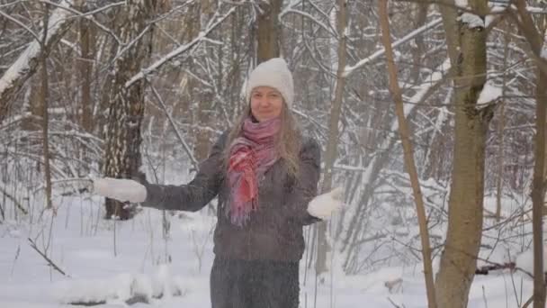 Счастливая молодая женщина играет со снегом — стоковое видео