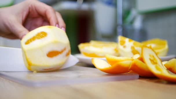 Обрезание всего апельсина на доске, закрытие видео — стоковое видео