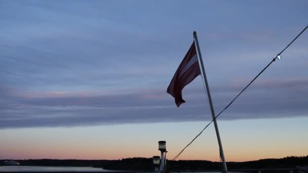 Drapeau letton sur un ferry au coucher du soleil — Video