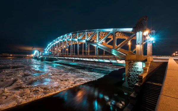 Geceleri güzel Bolsheokhtinsky köprüsü. Kemerli köprünün demir yapısı. Metal kirişler, aralıklar, cıvatalar ve perçinler. Köprünün altındaki kirişler ve perçin yapısı. Güzel duvar kağıdı..