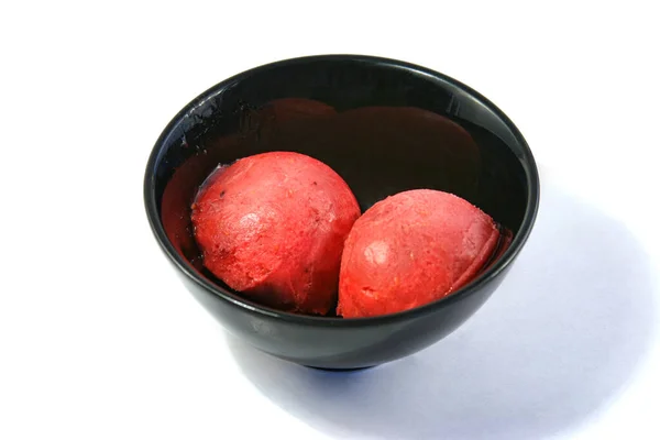 Beyaz arka planda bir kasede iki top dondurma. Beyaz arka planda izole edilmiş iki doğal erimiş dondurma topu. Yüksek açılı bir kepçe vanilyalı dondurma. 