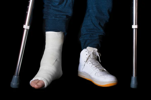 Mladý muž se poranil kotník a nohu obsazení — Stock fotografie