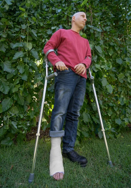 Joven con una pierna echada en un jardín —  Fotos de Stock