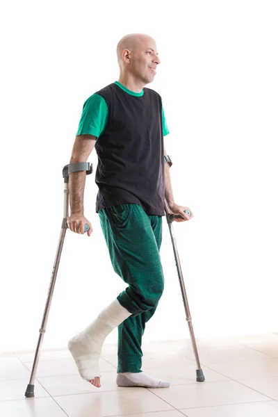 Молодой человек с отлитыми ногами и костылями — стоковое фото